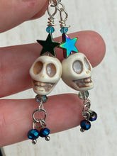 Load image into Gallery viewer, Mini Howlite Skull Bead Earrings, Stardust Galaxy Cosmos large star shaped rainbow hematite beads and light blue glass bead for a pastel goth vibe. Two small dark blue glass beads on the bottom to add some movement. Perfect for a witch, goth, or day of the dead outfit. You can dress these up or down, it will definitely give your outfit a unique look. Measurements: 2 ” in length