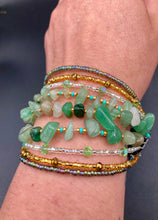 Load image into Gallery viewer, This Bohemian, Hippie Natural Genuine Stone Bracelet is composed of nine strands of shimmery multi-color glass beads and natural green aventurine chip stones. This striking, nature-inspired style showcases a vibrant blend of gold, silver, green, and turquoise beads, with a range of sizes, including both large and small round beads. Measurements: Bracelet: 8 1/4" in length