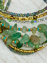 Load image into Gallery viewer, This Bohemian, Hippie Natural Genuine Stone Bracelet is composed of nine strands of shimmery multi-color glass beads and natural green aventurine chip stones. This striking, nature-inspired style showcases a vibrant blend of gold, silver, green, and turquoise beads, with a range of sizes, including both large and small round beads. Measurements: Bracelet: 8 1/4" in length