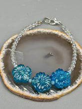 Load image into Gallery viewer, This light blue pressed glass floral bracelet is a sophisticated addition to any summer look. Its iridescent shimmer finish adds a classy touch to its intricate metal wire and lobster claw clasp. Perfect for any nature-inspired wardrobe. Measurements: Bracelet: 8" in length