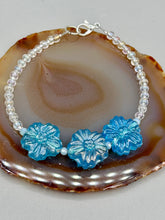 Load image into Gallery viewer, This light blue pressed glass floral bracelet is a sophisticated addition to any summer look. Its iridescent shimmer finish adds a classy touch to its intricate metal wire and lobster claw clasp. Perfect for any nature-inspired wardrobe. Measurements: Bracelet: 8" in length
