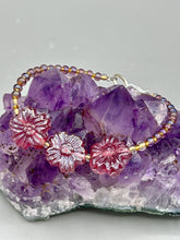 Load image into Gallery viewer, This light purple-pink pressed glass floral beaded bracelet offers delightful detailing with its iridescent shimmer finish. Constructed with metal wire and a lobster claw clasp for secure closure. Measurements: Bracelet: 8" in length