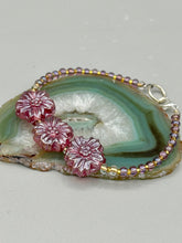 Load image into Gallery viewer, This light purple-pink pressed glass floral beaded bracelet offers delightful detailing with its iridescent shimmer finish. Constructed with metal wire and a lobster claw clasp for secure closure. Measurements: Bracelet: 8" in length