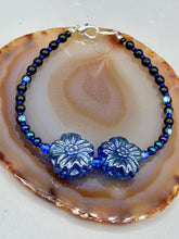 Load image into Gallery viewer, This Dark Blue Violet Pressed Glass Floral Beaded Bracelet features exquisitely detailed components with an iridescent shimmer finish. The piece is crafted with metal wire and a lobster claw clasp.  Measurements:  Bracelet: 8" in length