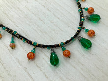 Load image into Gallery viewer, This necklace is the perfect addition to any collection, boasting a dark, elegant aesthetic inspired by nature. Comprised of two strands of glass beads with a variety of shapes and colors, it offers subtle autumnal vibrancy with its orange and green pumpkin-shaped glass beads. This piece is full of shimmer and complexity, providing unique depth and flair. Necklace is 16 1/2” in length, can be adjusted up to 18 1/2"