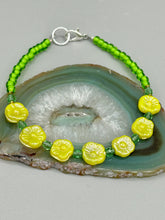 Load image into Gallery viewer, This delicate jewelry displays an array of gentle hues, vibrant yet soft.This light yellow pressed glass floral beaded bracelet and earrings set features an iridescent shimmer finish and is crafted with metal wire and a lobster claw clasp for easy closure. Measurements: Bracelet: 8 1/2" in length Earrings: 1 1/4" length