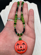 Load image into Gallery viewer, All Hallows Eve Pumpkin Necklace, Dark Souls Goth Necklace, Trick Or Treat, Halloween Spirit Costume Jewelry, Jack O Lantern PendantThis 25mm bright orange pumpkin bead pendant necklace is a perfect complement to any Halloween ensemble. It is additionally enhanced by shimmery glass beads in classic Halloween hues, such as black, dark green, and light green. Measurements: Necklace is 19”