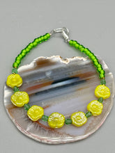 Load image into Gallery viewer, This delicate jewelry displays an array of gentle hues, vibrant yet soft.This light yellow pressed glass floral beaded bracelet and earrings set features an iridescent shimmer finish and is crafted with metal wire and a lobster claw clasp for easy closure. Measurements: Bracelet: 8 1/2" in length Earrings: 1 1/4" length