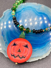 Load image into Gallery viewer, All Hallows Eve Pumpkin Necklace, Dark Souls Goth Necklace, Trick Or Treat, Halloween Spirit Costume Jewelry, Jack O Lantern PendantThis 25mm bright orange pumpkin bead pendant necklace is a perfect complement to any Halloween ensemble. It is additionally enhanced by shimmery glass beads in classic Halloween hues, such as black, dark green, and light green. Measurements: Necklace is 19”