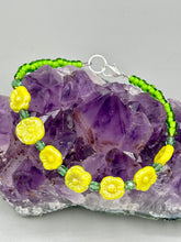 Load image into Gallery viewer, This delicate jewelry displays an array of gentle hues, vibrant yet soft.This light yellow pressed glass floral beaded bracelet and earrings set features an iridescent shimmer finish and is crafted with metal wire and a lobster claw clasp for easy closure. Measurements: Bracelet: 8 1/2" in length Earrings: 1 1/4" length
