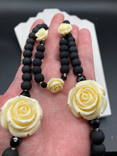 Load image into Gallery viewer, This Cocktail Chic Long Beaded Necklace is a unique piece that can be styled in different ways. Crafted with black flat matte glass beads for a luxurious look, the necklace is complemented by small and large white rose beads for contrast. The intricate petal details give the piece an extra special touch. This set is a simple and elegant pieces, very versatile looks and comes with a pair of matching earrings. Perfect cocktail chic attire, fancy wedding necklace, a minimalist look.