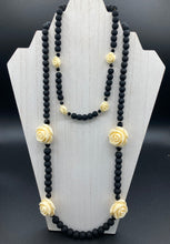 Load image into Gallery viewer, This Cocktail Chic Long Beaded Necklace is a unique piece that can be styled in different ways. Crafted with black flat matte glass beads for a luxurious look, the necklace is complemented by small and large white rose beads for contrast. The intricate petal details give the piece an extra special touch. This set is a simple and elegant pieces, very versatile looks and comes with a pair of matching earrings. Perfect cocktail chic attire, fancy wedding necklace, a minimalist look.