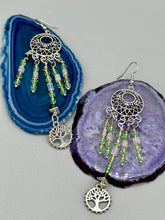 Load image into Gallery viewer, Be mesmerized by these large cascade style earrings, featuring five delicate strands of light green, iridescent and gold-tone beads with a tree of life charm for an eye-catching effect. Perfect for whimsical, nature-inspired looks, these earrings will liven up any outfit. Measurements: 3 3/4” in length