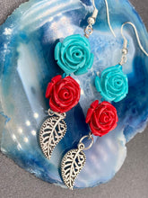 Load image into Gallery viewer, This alluring set of earrings captures the vibrant, enchanting beauty of the desert, featuring blue turquoise and bright red accents, highly detailed quartize rose beads and intricate silver plated leaf, providing fun movement. Perfect for those who love the Southwestern feel, Dia De Los Muertos, they can be dressed up or down, giving your fashion a unique touch. Measurements: 2” in length