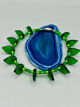 Load image into Gallery viewer, This nature-inspired jewelry is crafted from shimmering glass beads in shades of light and dark green as well as clear iridescent and gold tones. Light and dark green glass leaf beaded anklet and earrings provide intricate detailing. Crafted with metal wire and a barrel screw clasp, they offer a secure fit.