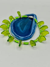 Load image into Gallery viewer, This nature-inspired jewelry is crafted from shimmering glass beads in shades of light and dark green as well as clear iridescent and gold tones. Light and dark green glass leaf beaded anklet and earrings provide intricate detailing. Crafted with metal wire and a barrel screw clasp, they offer a secure fit.
