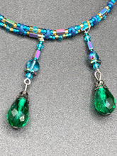 Load image into Gallery viewer, This Victorian-style necklace features a combination of green and blue glass beads, and rectangular, rainbow hematite beads for a layered and textured effect. The dramatic dark-green glass tear drops dangling from the strands provide additional depth and sophistication. Double-hole flat matte blue beads are used to hold the two strands together, creating a collar-like shape that softly cascades over your neckline. It is a striking, bold and elegant accessory.