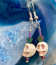 Load image into Gallery viewer, hanging skulls and rainbow hematite heart shaped beads earrings fish hook style are 1 1/2”