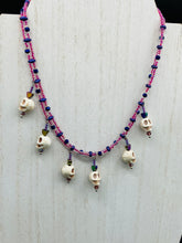 Load image into Gallery viewer, Dark gothic, elegant, and romantic necklace contains two beaded strands of pink beads that contain a dash of purple, blue, and gold hues. Tiny skull howlite skulls with rainbow hematite heart shaped beads to give this necklace a cute and romantic style. Comes with matching earrings. Necklace is 14”adjustable up to 18" in length - hanging skulls and hearts pendant are 1”