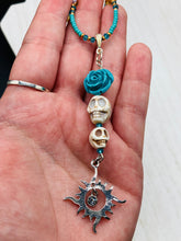 Load image into Gallery viewer, Enchanting Southwest Style Jewelry. Necklace captures Frida Kahlo's signature floral crown on her head. Howlite skull beads topped with turquoise quartize floral beads, style to represent mother and child. Dangling shimmery sun charm pendant to incorporated some movement. Chingona, Cabrona, Latina Chicana, Goth, Vampire Goth, Dark Witchy Style. This piece of jewelry can be worn for inspiration or a great Dia De Los Muertos jewelry piece. Necklace is 20” in length - flower, skull, and sun pendant is 3”