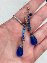Load image into Gallery viewer, This beautifully and bold set of glass beaded earrings were inspired by the vibrant and beautiful colors of the galaxy and the cosmos full of colors that makes a stunning statement piece of jewelry. Rectangular rainbow Hematite beads add a different texture to the style. This is a bold piece of jewelry, a “must have”to your collection. Measurements: 2” in length