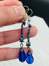 Load image into Gallery viewer, This beautifully and bold set of glass beaded earrings were inspired by the vibrant and beautiful colors of the galaxy and the cosmos full of colors that makes a stunning statement piece of jewelry. Rectangular rainbow Hematite beads add a different texture to the style. This is a bold piece of jewelry, a “must have”to your collection. Measurements: 2” in length