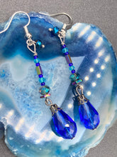 Load image into Gallery viewer, This beautifully and bold set of glass beaded earrings were inspired by the vibrant and beautiful colors of the galaxy and the cosmos full of colors that makes a stunning statement piece of jewelry. Rectangular rainbow Hematite beads add a different texture to the style. This is a bold piece of jewelry, a “must have”to your collection. Measurements: 2” in length