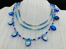 Load image into Gallery viewer, This exquisite Winter Frost Nature Inspired Jewelry has all your style needs covered. A detailed, glass beaded necklace featuring an array of blues, silver and gold tones adorns your neck to add a touch of elegance to any look. Effortlessly dress it up or down to complement any ensemble. Measurements: Necklace is 14” in length, can be adjusted up to 18"