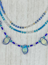 Load image into Gallery viewer, This exquisite Winter Frost Nature Inspired Jewelry has all your style needs covered. A detailed, glass beaded necklace featuring an array of blues, silver and gold tones adorns your neck to add a touch of elegance to any look. Effortlessly dress it up or down to complement any ensemble. Measurements: Necklace is 14” in length, can be adjusted up to 18"