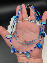 Load image into Gallery viewer, This exquisite Winter Frost Nature Inspired Jewelry has all your style needs covered. A detailed, glass beaded necklace featuring an array of blues, silver and gold tones adorns your neck to add a touch of elegance to any look. Effortlessly dress it up or down to complement any ensemble. Measurements: Necklace is 14” in length, can be adjusted up to 18"
