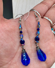 Load image into Gallery viewer, This stunning, one of a kind pair of celestial beaded earrings is a bold addition to any jewelry collection. Crafted with vibrant blue glass beads, the color contains varied shades of blue, purple, and hints of gold to create unique texture. The design is inspired by the awe-inspiring beauty of the majestic galaxy. Measurements: 2” in length