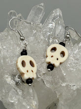 Load image into Gallery viewer, These stylish skull earrings are perfect for adding a unique flair to any outfit. Whether you're looking for a Dia De Los Muertos accessory or simply looking to draw inspiration, these goth pieces perfectly capture the vampire goth, witchy, dark, Chingona Cabrona, Latina Chicana styles.  Measurements: 1 1/4 ” in length