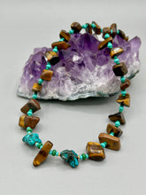 Load image into Gallery viewer, This bold earthy tone necklace presents an eye-catching combination of natural tigers eye stone chips and blue-green turquoise glass beads, making it an ideal statement piece. Measurements: Necklace is 18 3/4 " in length adjustable to 20"