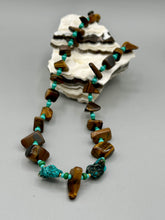 Load image into Gallery viewer, This bold earthy tone necklace presents an eye-catching combination of natural tigers eye stone chips and blue-green turquoise glass beads, making it an ideal statement piece. Measurements: Necklace is 18 3/4 " in length adjustable to 20"