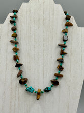Load image into Gallery viewer, This bold earthy tone necklace presents an eye-catching combination of natural tigers eye stone chips and blue-green turquoise glass beads, making it an ideal statement piece. Measurements: Necklace is 18 3/4 " in length adjustable to 20"