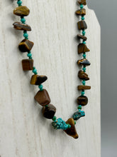 Load image into Gallery viewer, This bold earthy tone necklace presents an eye-catching combination of natural tigers eye stone chips and blue-green turquoise glass beads, making it an ideal statement piece. Measurements: Necklace is 18 3/4 " in length adjustable to 20"