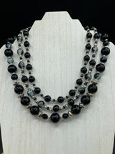 Load image into Gallery viewer, This stunning Shimmery black glass and floral metal beaded necklace features three long strands which gracefully drape around the neck. Its bold elegance is the perfect accessory for a cocktail chic outfit, a wedding, or a more minimalist look.  Measurements:    Necklace is 16 1/4” in length - adjustable to 18"