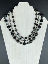 Load image into Gallery viewer, This stunning Shimmery black glass and floral metal beaded necklace features three long strands which gracefully drape around the neck. Its bold elegance is the perfect accessory for a cocktail chic outfit, a wedding, or a more minimalist look.  Measurements:    Necklace is 16 1/4” in length - adjustable to 18"