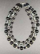 Load image into Gallery viewer, This stunning Shimmery black glass and floral metal beaded necklace features three long strands which gracefully drape around the neck. Its bold elegance is the perfect accessory for a cocktail chic outfit, a wedding, or a more minimalist look.  Measurements:    Necklace is 16 1/4” in length - adjustable to 18"