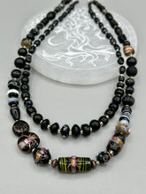 Load image into Gallery viewer, Add flair to your look with this unique large and chunky hand beaded necklace. Featuring a wide variety of mixed black glass beads in different sizes and shapes, this intricately-crafted statement piece offers a bold, hippie-chic, shabby-chic, and bohemian style. Measurements: Necklace is 18” in length, can be adjusted up to 20"