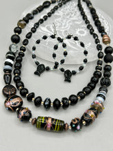 Load image into Gallery viewer, This sophisticated pair of earrings features a black glass fish bead, complemented by small iridescent and dark gray color glass beads, with eye and fin details. Measurements: 2” in length