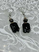 Load image into Gallery viewer, Elegantly crafted from black rectangular and circular glass beads, these dainty earrings offer a versatile style that can effortlessly elevate any ensemble. Measurements: 1 3/8” in length