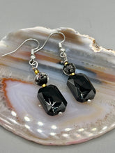 Load image into Gallery viewer, Elegantly crafted from black rectangular and circular glass beads, these dainty earrings offer a versatile style that can effortlessly elevate any ensemble. Measurements: 1 3/8” in length