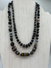 Load image into Gallery viewer, Add flair to your look with this unique large and chunky hand beaded necklace. Featuring a wide variety of mixed black glass beads in different sizes and shapes, this intricately-crafted statement piece offers a bold, hippie-chic, shabby-chic, and bohemian style. Measurements: Necklace is 18” in length, can be adjusted up to 20"