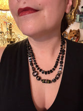 Load image into Gallery viewer, Add flair to your look with this unique large and chunky hand beaded necklace. Featuring a wide variety of mixed black glass beads in different sizes and shapes, this intricately-crafted statement piece offers a bold, hippie-chic, shabby-chic, and bohemian style. Measurements: Necklace is 18” in length, can be adjusted up to 20"