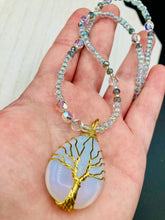 Load image into Gallery viewer, This opalite stone pendant with its shimmering hues of blue, gold, and pink is inspired by the whimsical beauty of nature. I created a beaded necklace using iridescent glass beads with the same colors of blue, gold, and pink to enhance the look of the Vibrant Tree Of Life Opalite Wired Stone Pendant. Measurements: Necklace is 20”