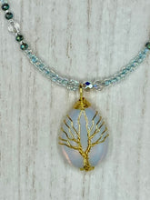 Load image into Gallery viewer, This opalite stone pendant with its shimmering hues of blue, gold, and pink is inspired by the whimsical beauty of nature. I created a beaded necklace using iridescent glass beads with the same colors of blue, gold, and pink to enhance the look of the Vibrant Tree Of Life Opalite Wired Stone Pendant. Measurements: Necklace is 20”
