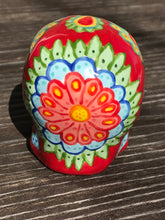 Load image into Gallery viewer, This hand-painted Mini Dia de Los Muertos ceramic skull art provides a vibrant representation of summertime blooms. Its fire red and nature-inspired design is unique, capturing the energy and beauty of a hot day at Meadowlark Gardens in Virginia. A perfect addition to any art collection. Measurements: H 2 3/4” x W 2” x D 2”