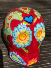 Load image into Gallery viewer, This hand-painted Mini Dia de Los Muertos ceramic skull art provides a vibrant representation of summertime blooms. Its fire red and nature-inspired design is unique, capturing the energy and beauty of a hot day at Meadowlark Gardens in Virginia. A perfect addition to any art collection. Measurements: H 2 3/4” x W 2” x D 2”