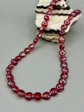 Load image into Gallery viewer, This ruby red heart-shaped glass beaded necklace features a shimmery and vivid iridescent hue, secured with a hook-eye clasp. Measurements:    Necklace is 19" in length